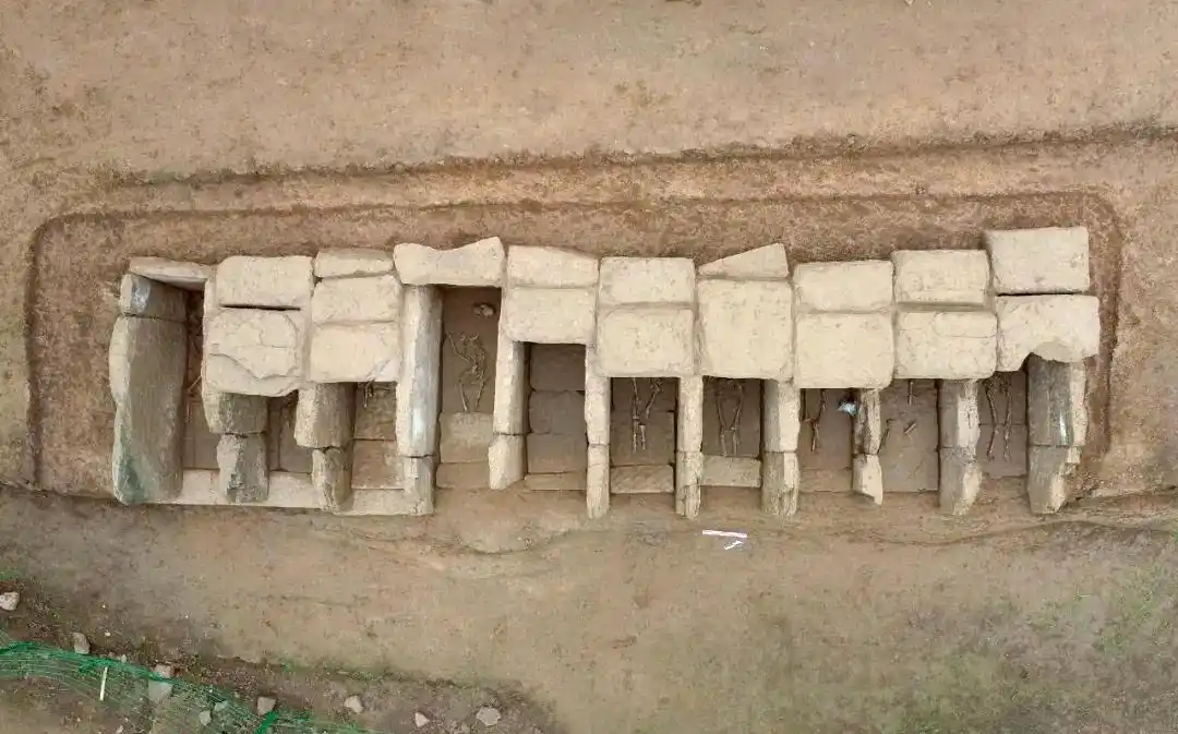 A single long row of about ten stone chambers
