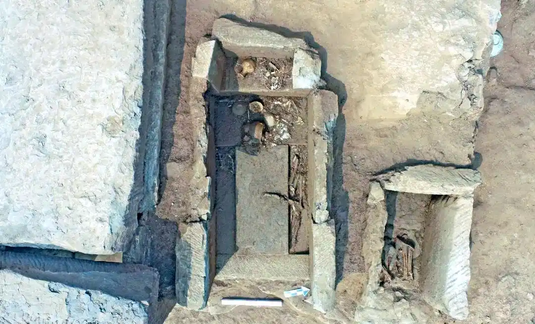 Opened chamber with skeletal remains and grave pottery