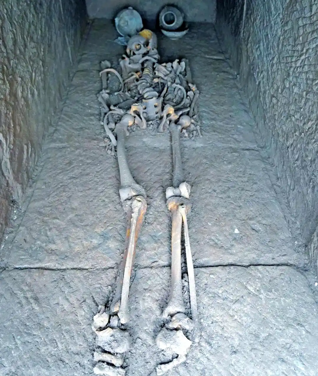 A burial in situ, supine and extended, with vessels at the head